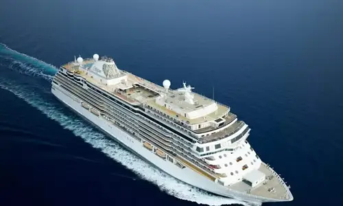 Large luxury cruise ship sailing across the open ocean, representing cruise travel and cruise terminal transportation services.